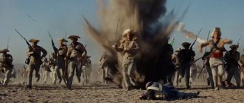 Movie still from “The Alamo” (1960), directed by John Wayne – A group of men running through the sand; Wide shot, Low angle