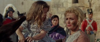 Movie still from “The Alamo” (1960), directed by John Wayne – Two women and a little girl in the background; Close Up shot, Over the shoulder angle
