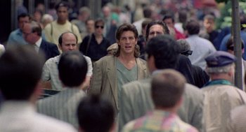 Movie still from “The Ambulance” (1990), directed by Larry Cohen – A crowd of people walking down a street; Medium shot, Over the shoulder angle