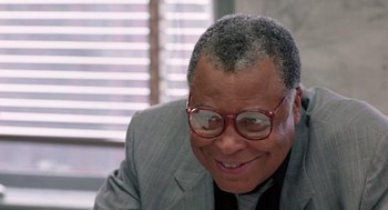 Movie still from “The Ambulance” (1990), directed by Larry Cohen – An older man wearing glasses and a suit; Close Up shot, Low angle