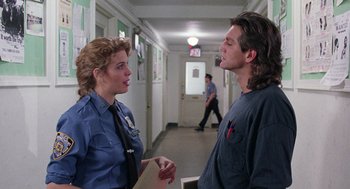 Movie still from “The Ambulance” (1990), directed by Larry Cohen – A woman and a man talking in a hallway; Medium shot, Over the shoulder angle