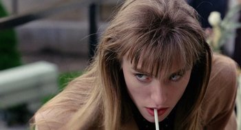 Movie still from “The Ambulance” (1990), directed by Larry Cohen – A woman is holding a cigarette in her mouth; Close Up shot, High angle