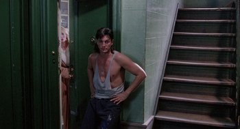 Movie still from “The Ambulance” (1990), directed by Larry Cohen – A man standing in front of a green door; Medium shot, Over the shoulder angle