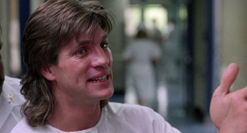 Movie still from “The Ambulance” (1990), directed by Larry Cohen – A person wearing a white t - shirt; Close Up shot, Over the shoulder angle