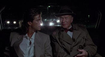 Movie still from “The Ambulance” (1990), directed by Larry Cohen – A man and a man in a suit and tie; Close Up shot, Over the shoulder angle