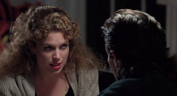 Movie still from “The Ambulance” (1990), directed by Larry Cohen – A woman with curly red hair talking to a man in front of a mirror; Close Up shot, Over the shoulder angle