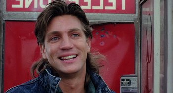 Movie still from “The Ambulance” (1990), directed by Larry Cohen – A person with long brown hair; Close Up shot, Low angle