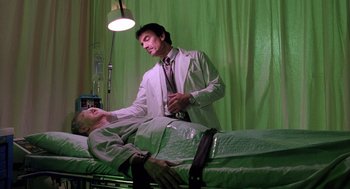 Movie still from “The Ambulance” (1990), directed by Larry Cohen – A man in a white lab coat standing next to a man in a white lab coat; Medium shot, Low angle