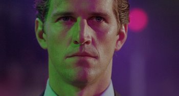 Movie still from “The Ambulance” (1990), directed by Larry Cohen – A person wearing a suit and tie; Close Up shot, Low angle