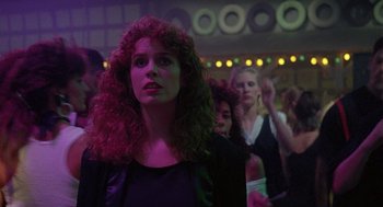 Movie still from “The Ambulance” (1990), directed by Larry Cohen – A group of women standing in a room with lights in the background; Medium shot, Over the shoulder angle