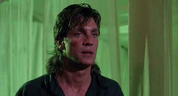 Movie still from “The Ambulance” (1990), directed by Larry Cohen – A person wearing a black shirt; Close Up shot, Low angle