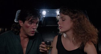 Movie still from “The Ambulance” (1990), directed by Larry Cohen – A man and a woman sitting next to each other holding a glass of wine; Close Up shot, Low angle