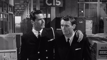 Movie still from “The Americanization of Emily” (1964), directed by Arthur Hiller – A couple of men standing next to each other; Medium shot, High angle