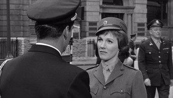 Movie still from “The Americanization of Emily” (1964), directed by Arthur Hiller – An old photo of a man and a woman in uniform; Medium shot, Over the shoulder angle