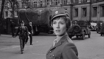 Movie still from “The Americanization of Emily” (1964), directed by Arthur Hiller – A black and white photo of a woman in a military uniform; Medium shot, Low angle