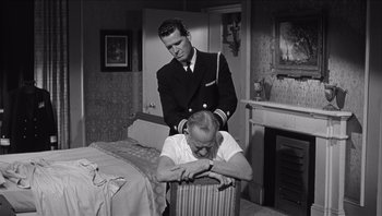 Movie still from “The Americanization of Emily” (1964), directed by Arthur Hiller – An old black and white photo of two men in a room; Medium shot, High angle