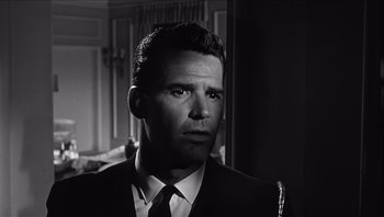 Movie still from “The Americanization of Emily” (1964), directed by Arthur Hiller – Black and white photograph of a man wearing a suit and tie; Close Up shot, Low angle