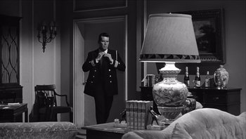 Movie still from “The Americanization of Emily” (1964), directed by Arthur Hiller – A black and white photo of a man taking a picture of himself; Medium shot, Low angle