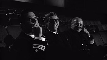 Movie still from “The Americanization of Emily” (1964), directed by Arthur Hiller – A group of three men standing next to each other; Medium shot, Low angle