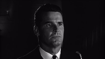 Movie still from “The Americanization of Emily” (1964), directed by Arthur Hiller – Black and white photograph of a man in a suit and tie; Close Up shot, Low angle