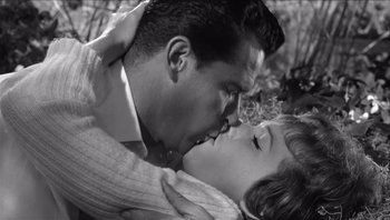 Movie still from “The Americanization of Emily” (1964), directed by Arthur Hiller – A man and a woman kissing in a wooded area; Close Up shot, High angle