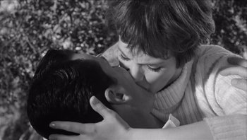 Movie still from “The Americanization of Emily” (1964), directed by Arthur Hiller – A man and a woman kissing each other in a park; Close Up shot, High angle