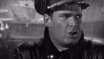 Movie still from “The Americanization of Emily” (1964), directed by Arthur Hiller – An old photo of a man in a uniform in the rain; Close Up shot, Low angle