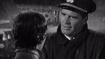 Movie still from “The Americanization of Emily” (1964), directed by Arthur Hiller – A black and white photo of a man and a woman in the rain; Close Up shot, Over the shoulder angle