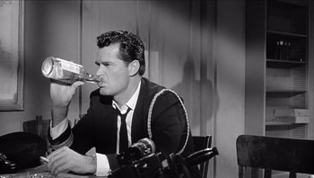 Movie still from “The Americanization of Emily” (1964), directed by Arthur Hiller – A black and white photo of a man drinking from a glass; Medium shot, High angle