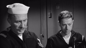 Movie still from “The Americanization of Emily” (1964), directed by Arthur Hiller – Two men in uniforms are standing next to each other; Medium shot, Low angle