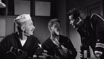 Movie still from “The Americanization of Emily” (1964), directed by Arthur Hiller – A group of men standing next to each other holding bottles; Medium shot, Low angle