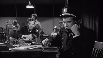 Movie still from “The Americanization of Emily” (1964), directed by Arthur Hiller – A black and white photo of a man talking on a phone; Medium shot, Low angle