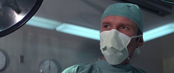 Movie still from “The Andromeda Strain” (1971), directed by Robert Wise – A man wearing a surgical mask in an operating room; Close Up shot, Low angle