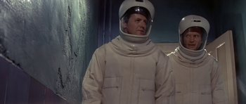 Movie still from “The Andromeda Strain” (1971), directed by Robert Wise – A man in a spacesuit and helmet standing in front of a wall; Medium shot, Low angle