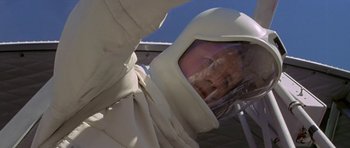 Movie still from “The Andromeda Strain” (1971), directed by Robert Wise – A person wearing a white suit and a helmet; Close Up shot, Overhead angle