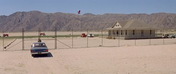 Movie still from “The Andromeda Strain” (1971), directed by Robert Wise – An american flag flies in the distance behind a fence in the desert; Extreme Wide shot, High angle