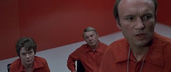 Movie still from “The Andromeda Strain” (1971), directed by Robert Wise – A man in red shirt looking into a mirror; Close Up shot, Over the shoulder angle