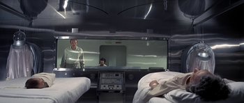 Movie still from “The Andromeda Strain” (1971), directed by Robert Wise – Two people in a room with a large mirror; Wide shot, Low angle