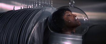 Movie still from “The Andromeda Strain” (1971), directed by Robert Wise – A woman in a space suit is sitting in a space ship; Close Up shot, High angle