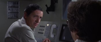 Movie still from “The Andromeda Strain” (1971), directed by Robert Wise – A man is talking to another man in a room; Close Up shot, Over the shoulder angle