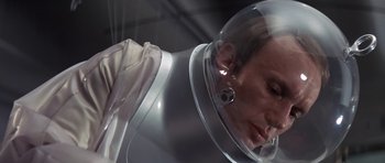 Movie still from “The Andromeda Strain” (1971), directed by Robert Wise – A man in a space suit looking down at his face; Close Up shot, Low angle
