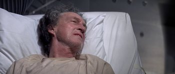 Movie still from “The Andromeda Strain” (1971), directed by Robert Wise – An older man laying in a hospital bed; Close Up shot, Low angle