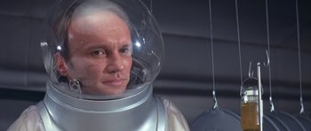 Movie still from “The Andromeda Strain” (1971), directed by Robert Wise – A man wearing a space suit and a helmet; Close Up shot, High angle