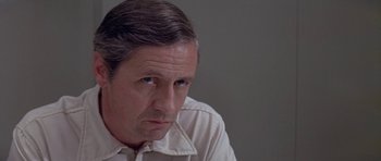 Movie still from “The Andromeda Strain” (1971), directed by Robert Wise – A person wearing a white shirt; Close Up shot, Over the shoulder angle