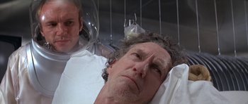 Movie still from “The Andromeda Strain” (1971), directed by Robert Wise – A man laying in a hospital bed next to another man; Close Up shot, Low angle