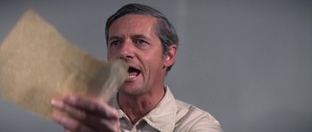 Movie still from “The Andromeda Strain” (1971), directed by Robert Wise – A person holding a piece of paper; Close Up shot, Over the shoulder angle