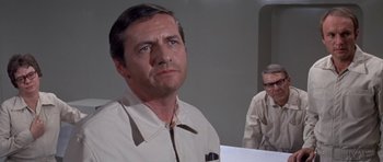 Movie still from “The Andromeda Strain” (1971), directed by Robert Wise – A man standing next to another man in a room; Close Up shot, Over the shoulder angle