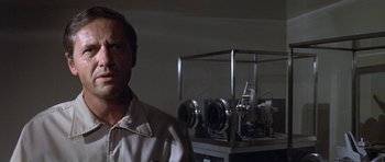Movie still from “The Andromeda Strain” (1971), directed by Robert Wise – A man standing in front of a machine in a room; Close Up shot, Low angle