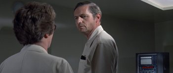 Movie still from “The Andromeda Strain” (1971), directed by Robert Wise – A man in a white shirt is looking at himself in the mirror; Close Up shot, Over the shoulder angle