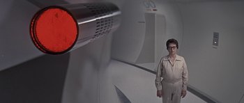 Movie still from “The Andromeda Strain” (1971), directed by Robert Wise – A man standing in front of a wall with a red light; Medium shot, High angle
